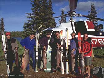 happy group with fresh catch, skis and heli